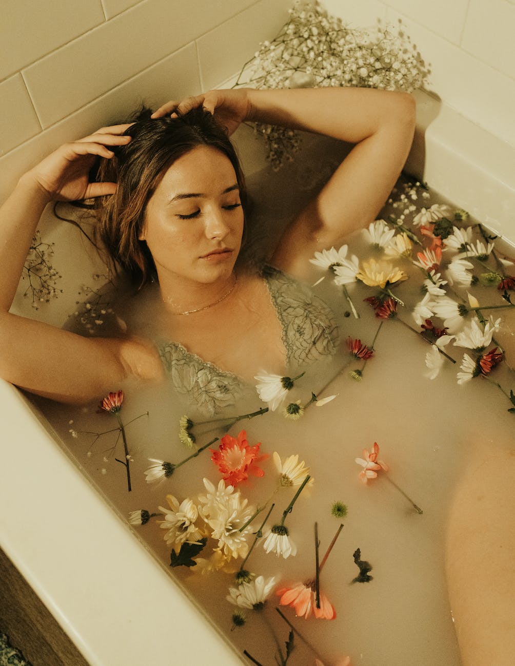 woman lying in a Beltane ritual bath with flowers