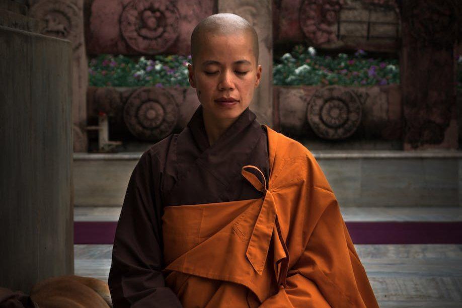 selective focus photography of monk during meditation