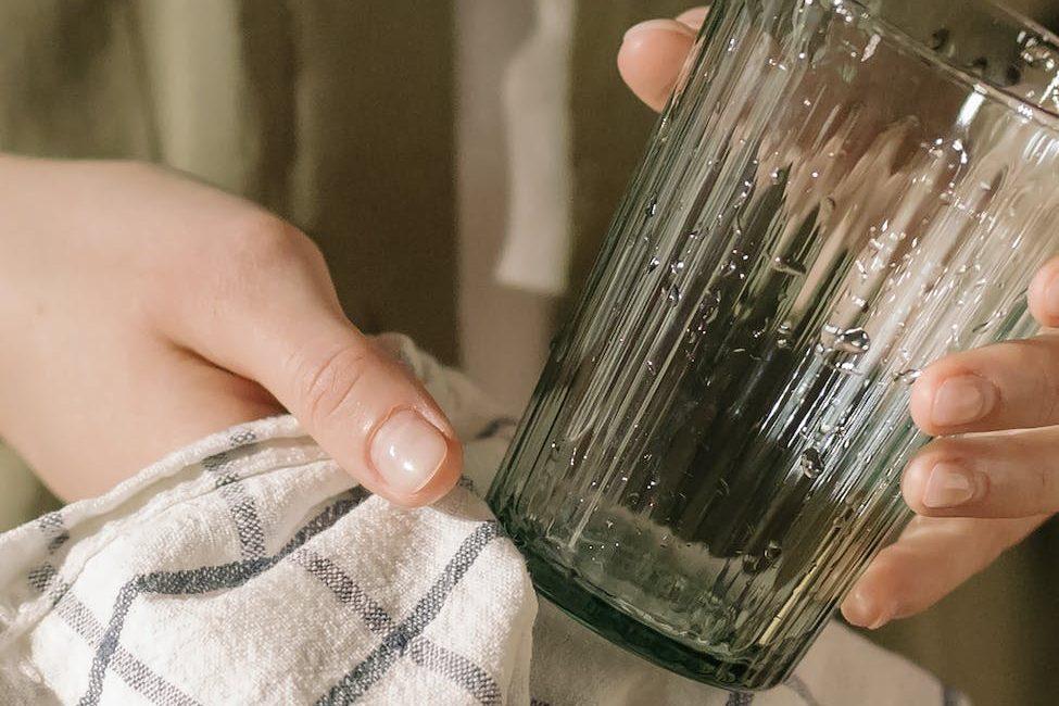 person holding green glass bottle