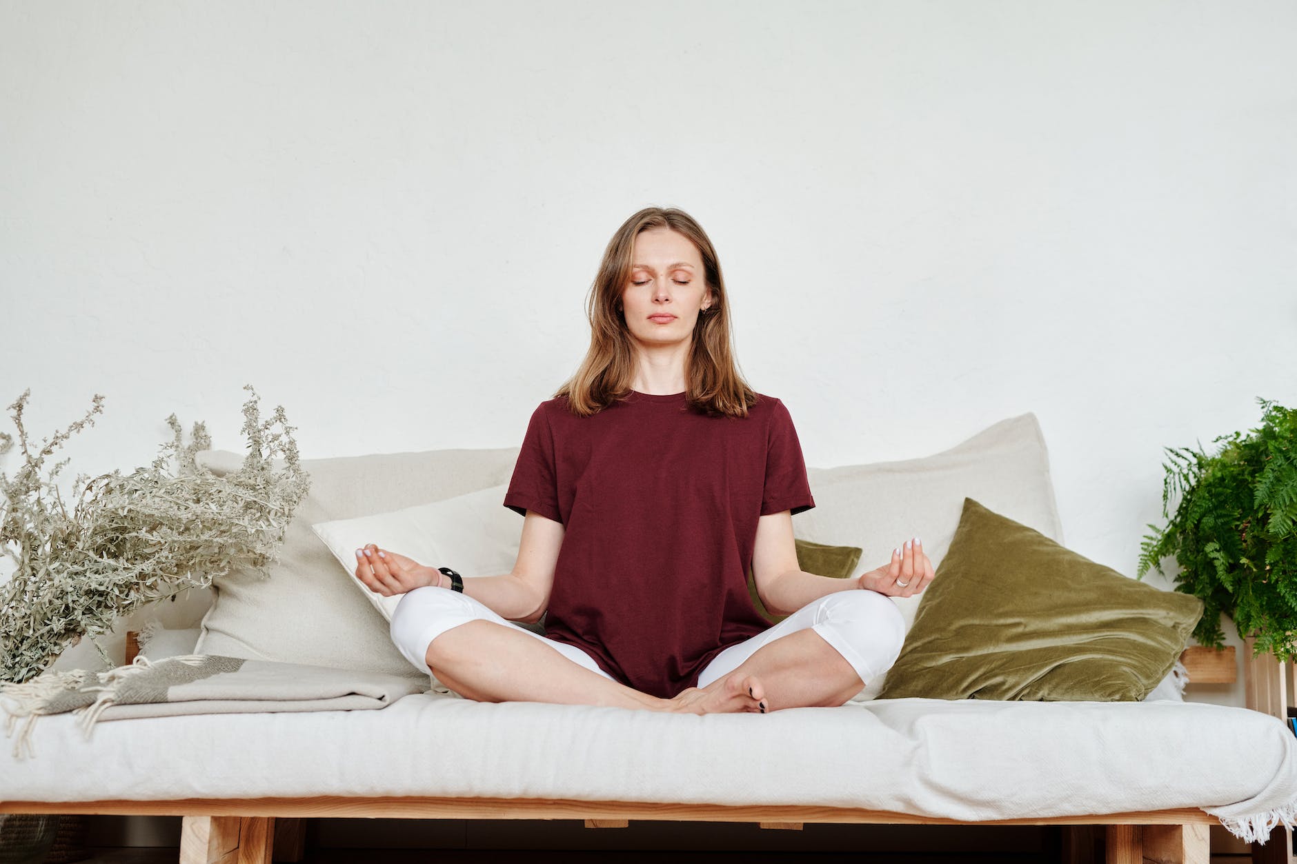 woman in red shirt sitting on couch in meditation