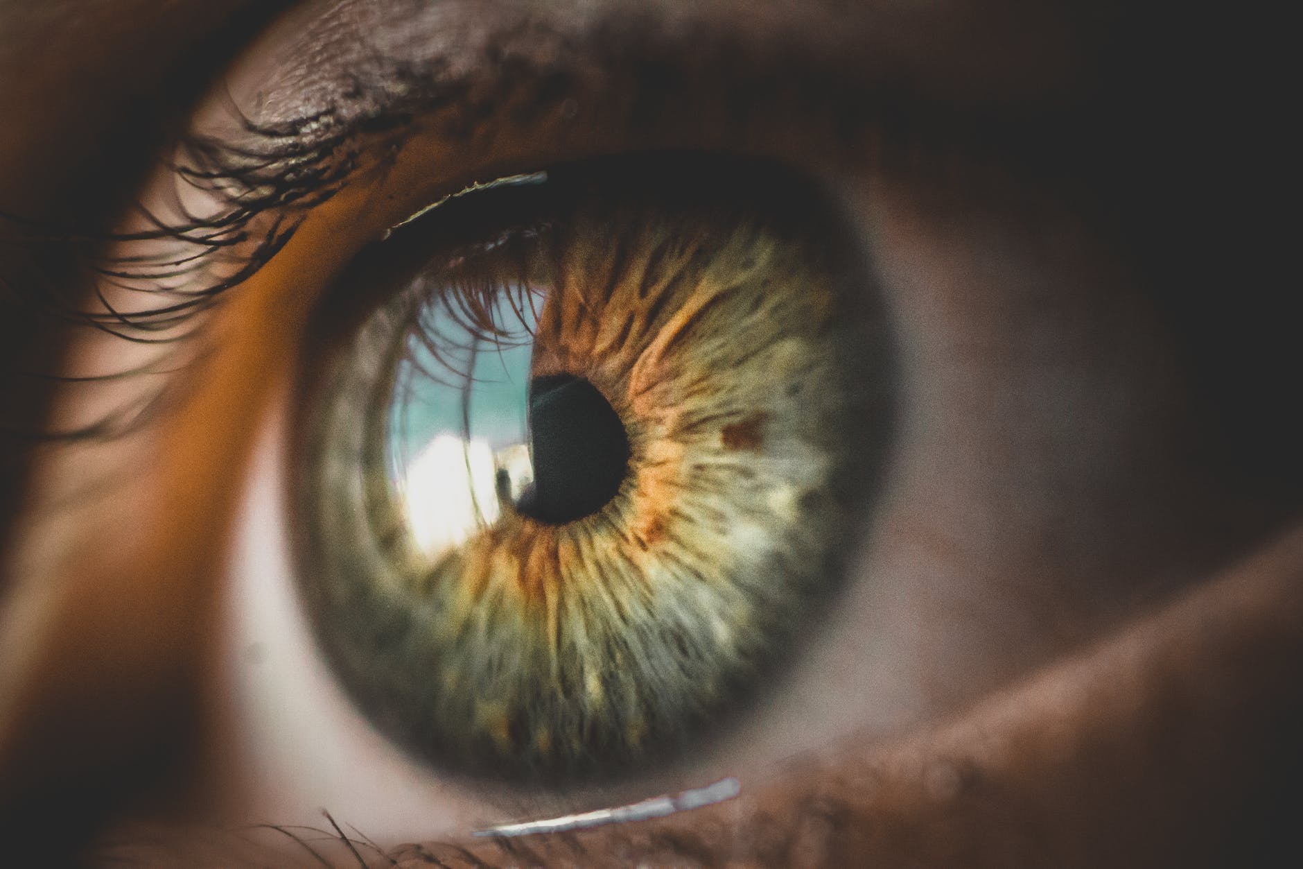 human green eye reflecting building and blue sky, illustrating: the power of positive visualization for mental clarity, focus and intention