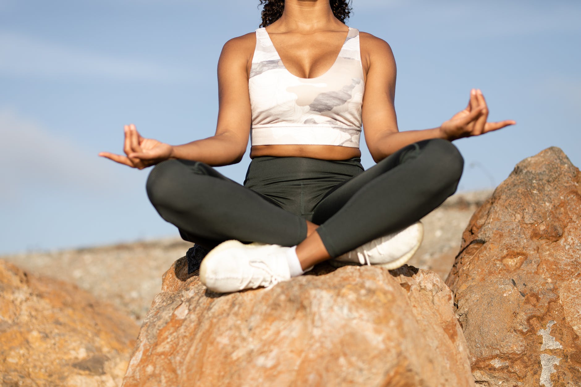 a woman sitting on a rock, exploring types of meditation and meditation techniques, as well as the benefits of meditation, mindfulness meditation, and how to meditate