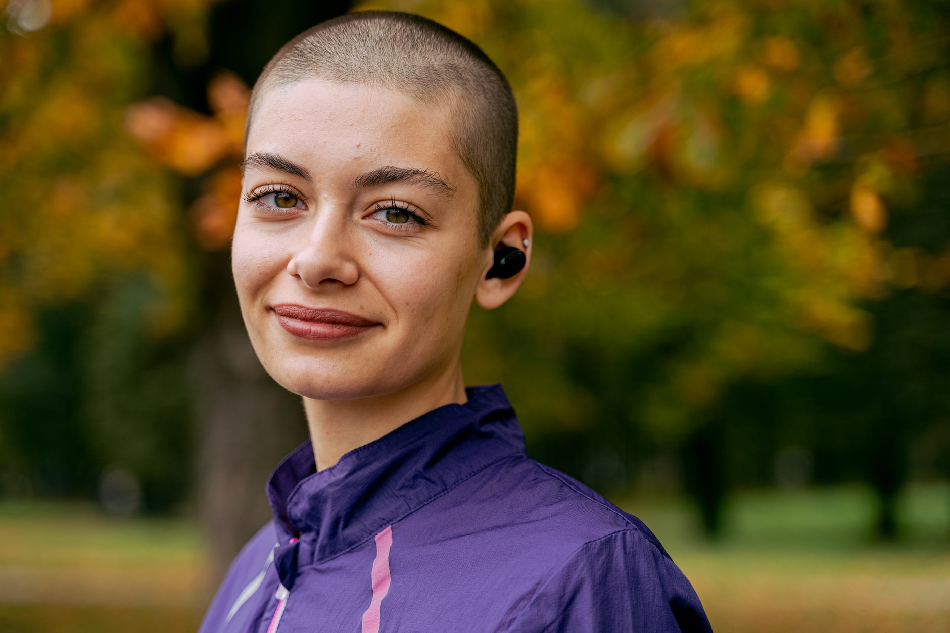 smiling woman in purple hoodie, illustrating mindfulness in daily life for holistic wellness