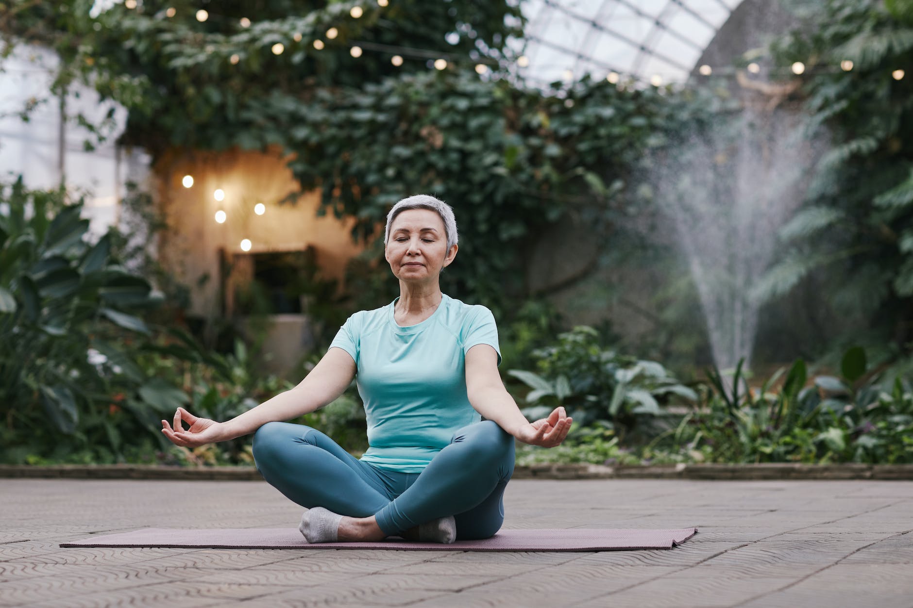 healthy woman meditating in a relaxation garden, illustrating types of meditation and mindfulness techniques