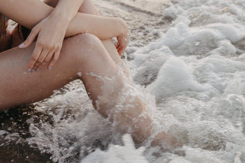 crop woman sitting near sea