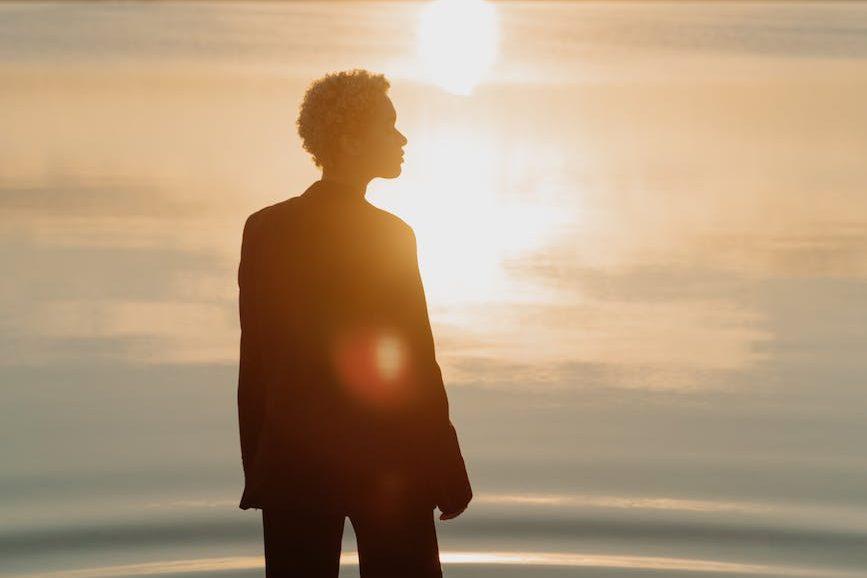 silhouette of a woman standing in the sea, illustrating spiritual growth, meditation, awareness, ego transcendence, and intuitive wisdom