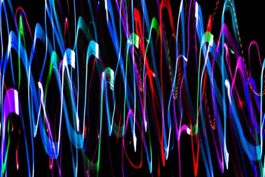 overlapping neon sound waves on black background