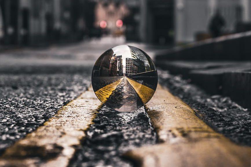 selective focus photo of lensball on asphalt road, illustrating lasting wellbeing, benefits of meditation, stress relief, emotional resilience, and mind-body connection