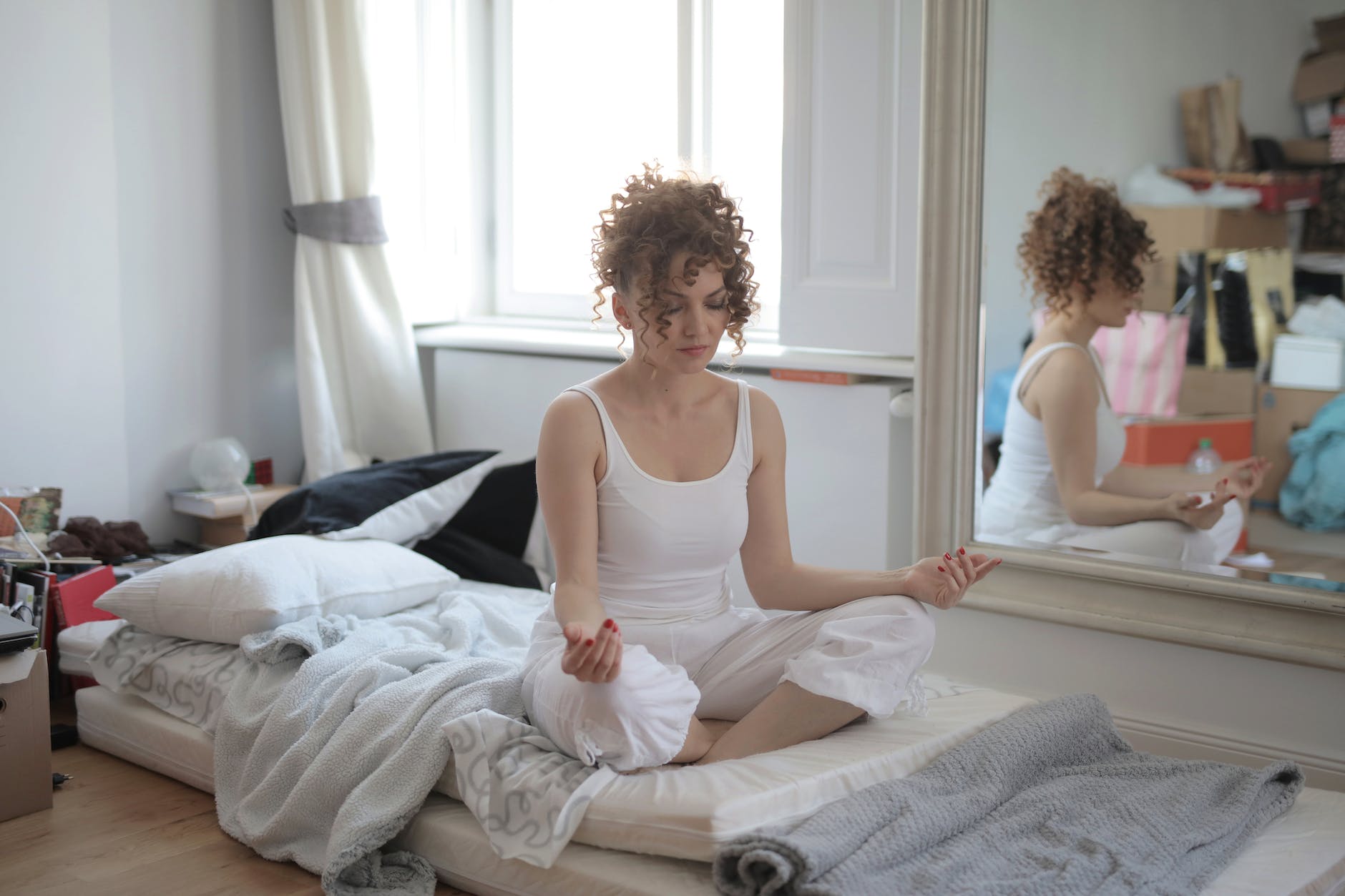 calm woman in lotus pose meditating after awakening at home, illustrating spiritual growth, meditation, awareness, ego transcendence, and intuitive wisdom