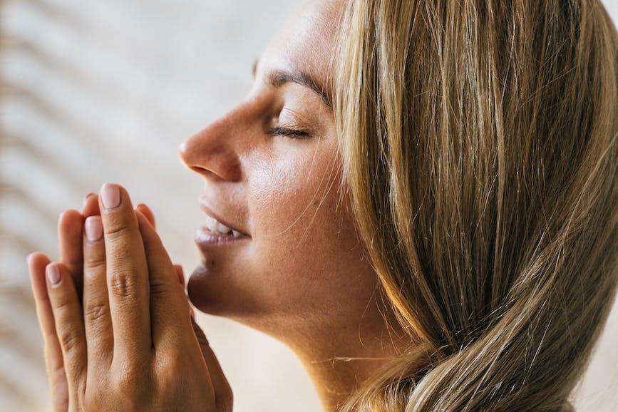 woman in wearing white robe praying