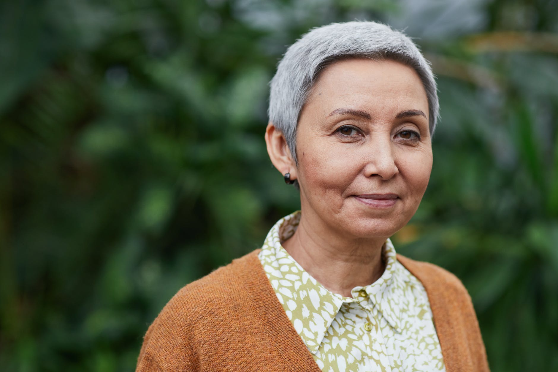 woman smiling at the camera, illustrating lasting wellbeing, benefits of meditation, stress relief, emotional resilience, and mind-body connection