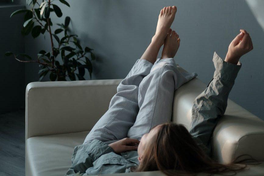 relaxed woman lounging on sofa with hand raised