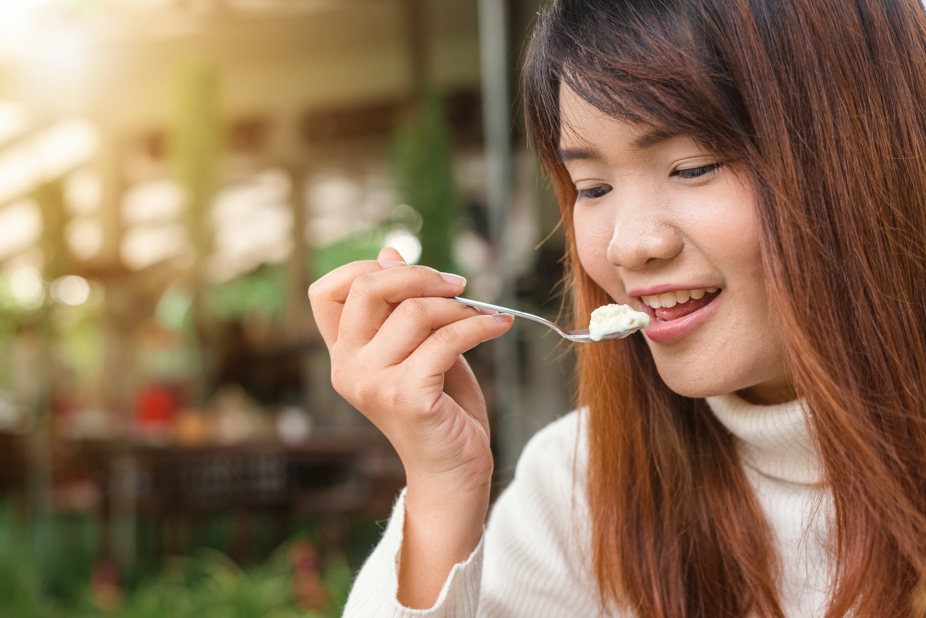 woman holding spoon trying to eat white food, practicing mindfulness, mindfulness in relationships, mindfulness at work, mindful communication, and daily mindfulness