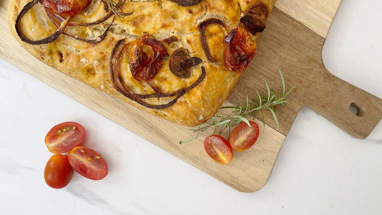 focaccia on a wooden board, illustrating: Mabon celebration, harvest bread recipe, autumn equinox recipes, seasonal bread, and a focaccia recipe