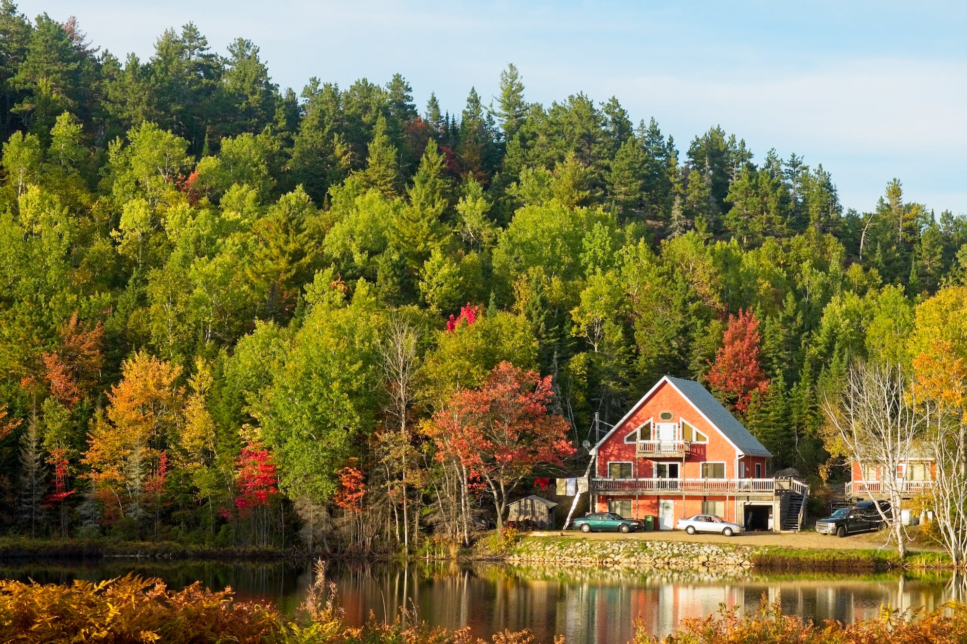 house by lake on edge of forest in autumn, evoking: Mabon wreath, autumn equinox craft, seasonal wreath symbolism, harvest celebration decor, and DIY fall wreath