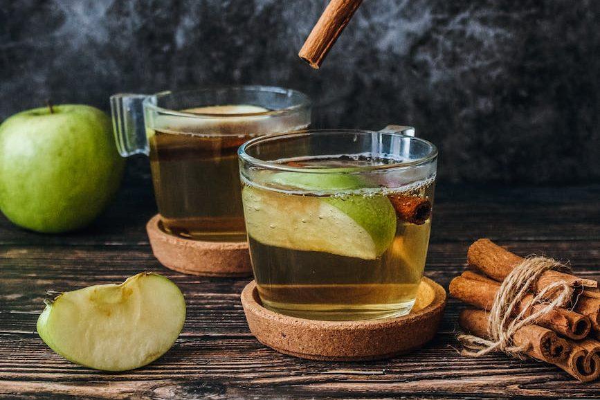 photo of slice green apple and cinnamon stick, illustrating: a feast ritual, sacred eating, Autumn Equinox, harvest celebration, and seasonal food