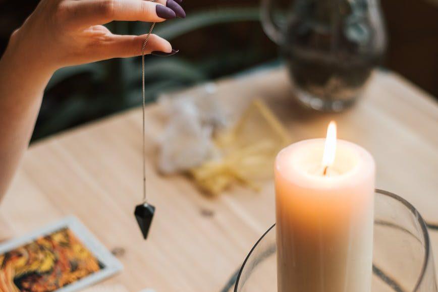 crop soothsayer with talisman and tarot cards near glowing candle, illustrating: Mabon divination, inner wisdom, Tarot spread, harvest reflection, and the Autumn Equinox