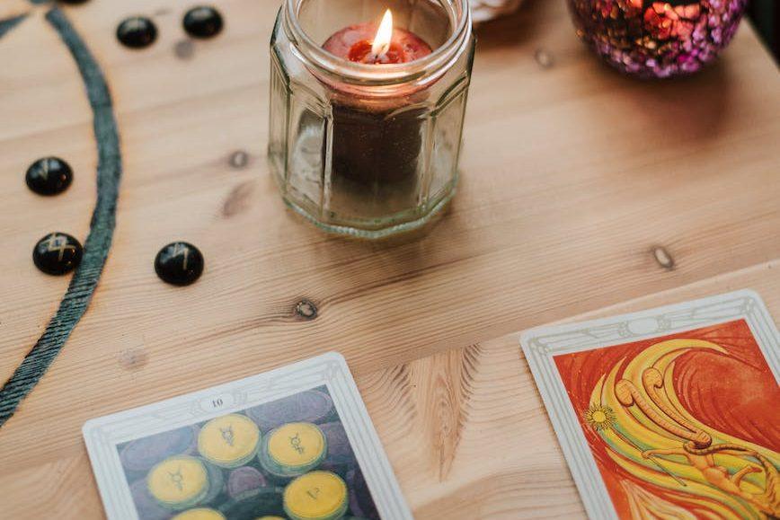 burning candles near tarot cards on table, illustrating: Mabon divination, inner wisdom, Tarot spread, harvest reflection, and the Autumn Equinox.