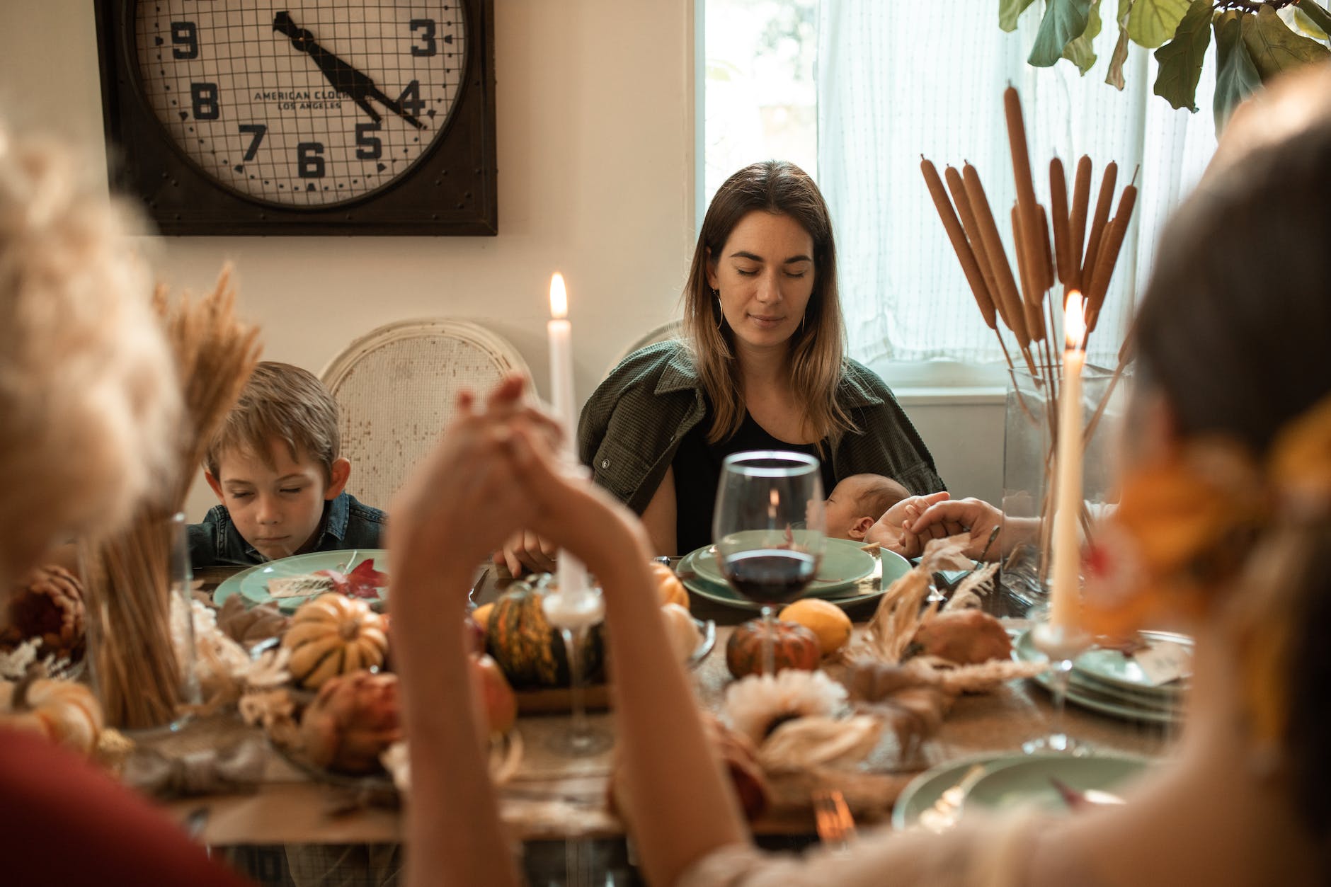 a family praying together before thanksgiving meal