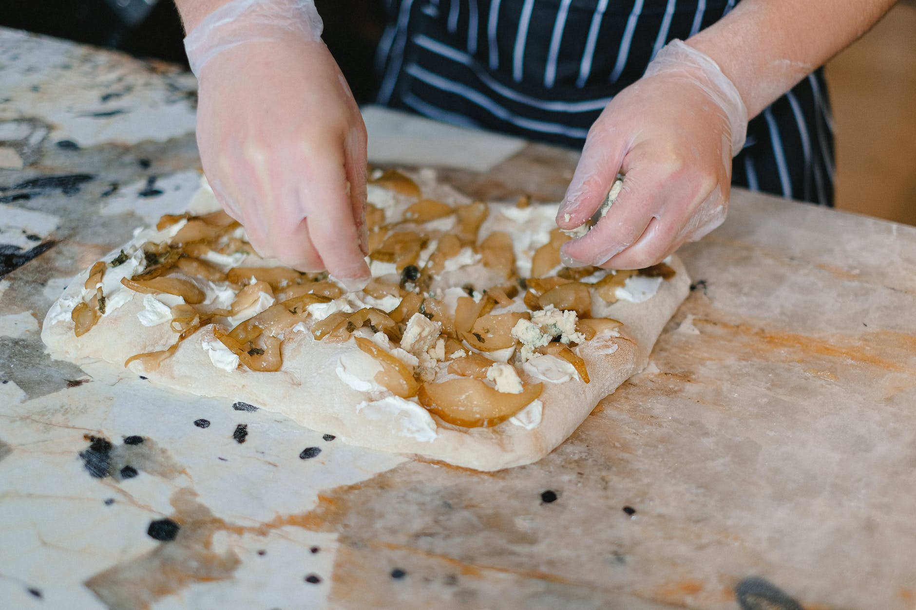 woman preparing focaccia with pears and cheese, illustrating: Mabon celebration, harvest bread recipe, autumn equinox recipes, seasonal bread, and a focaccia recipe
