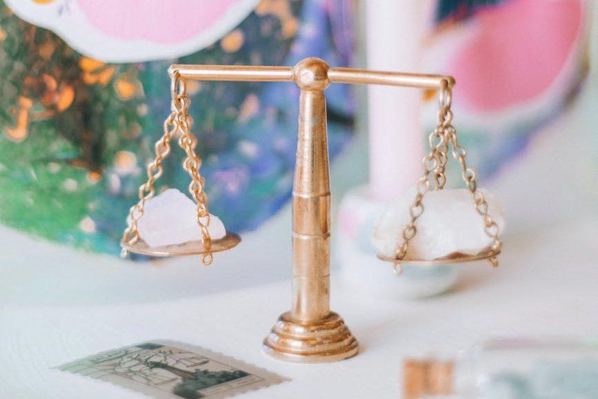 a scale with a gold balance on top of a table