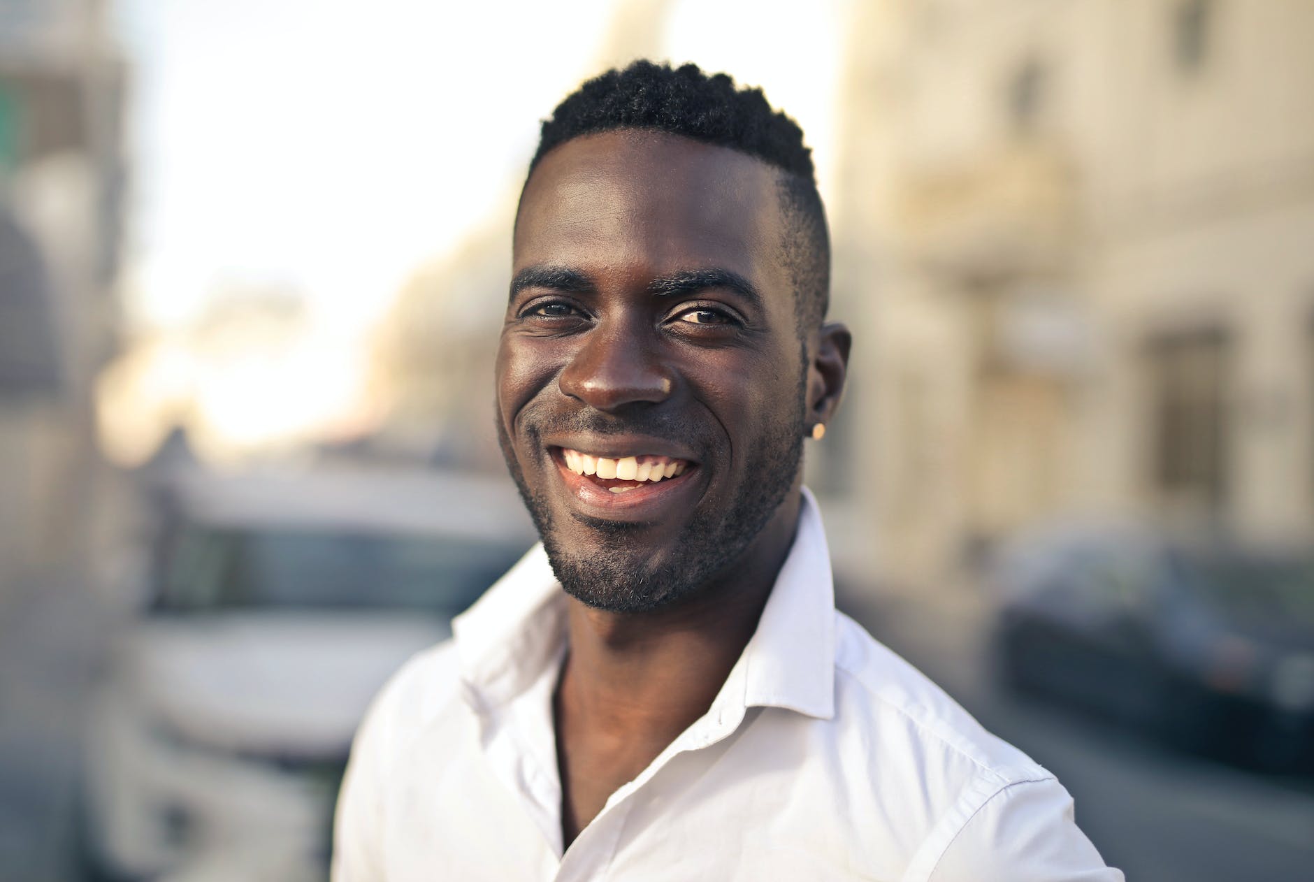 selective focus photo of smiling man in white dress shirt