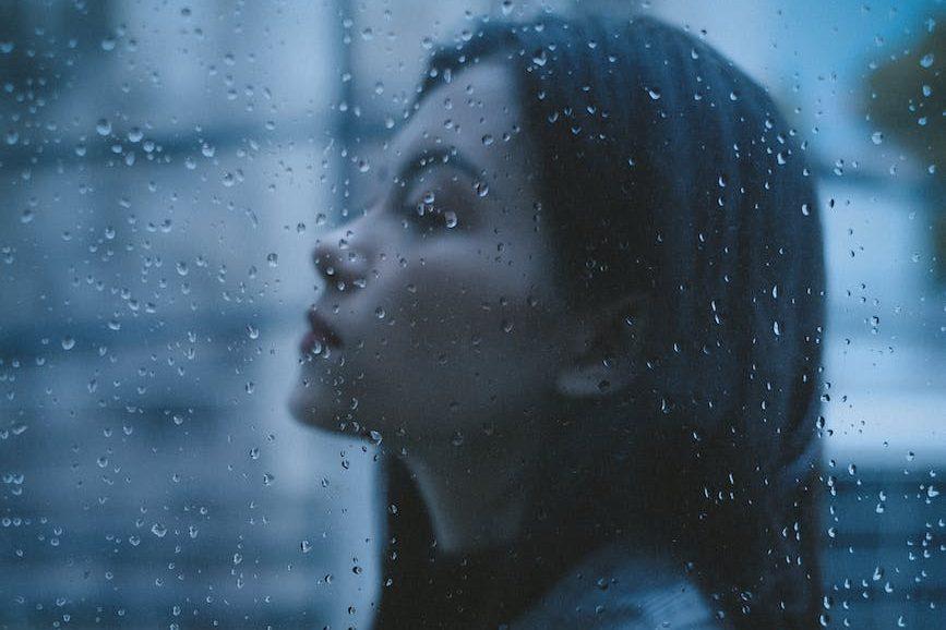 unhappy thoughtful teen girl arms crossed in rainy day