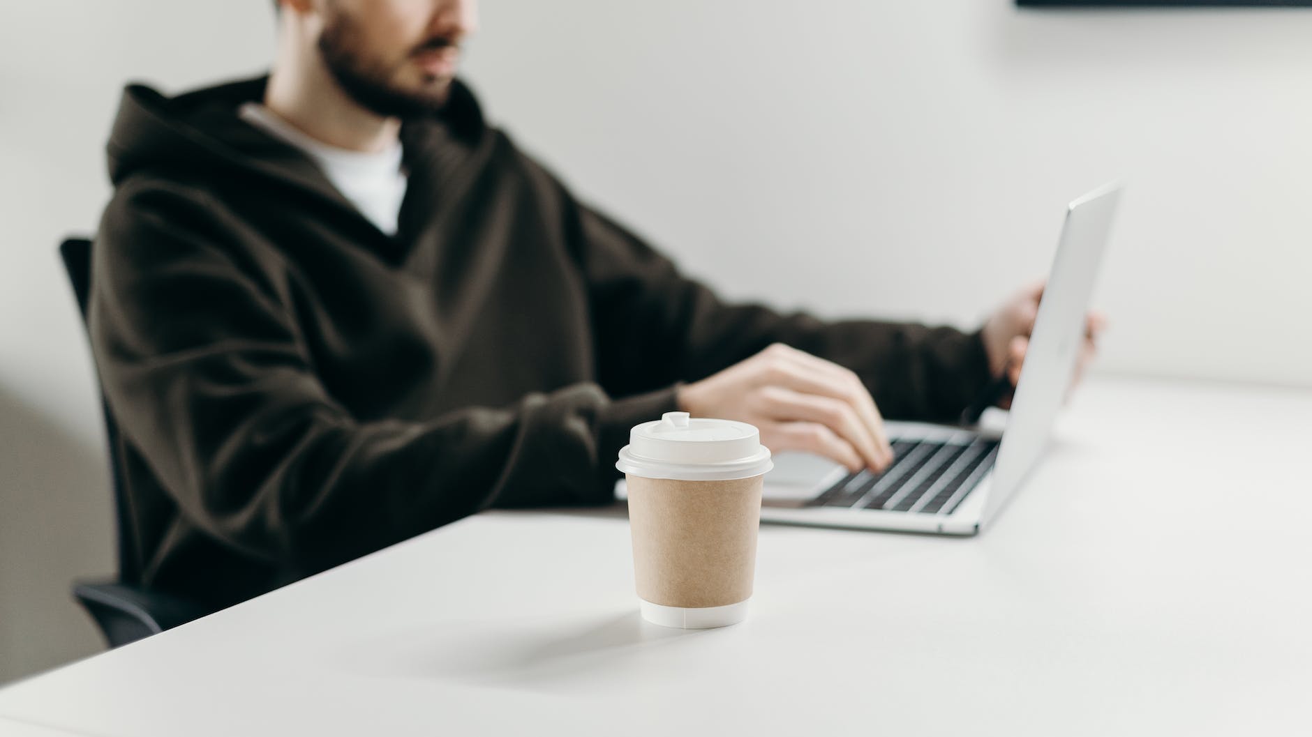 man in black sweater using macbook pro