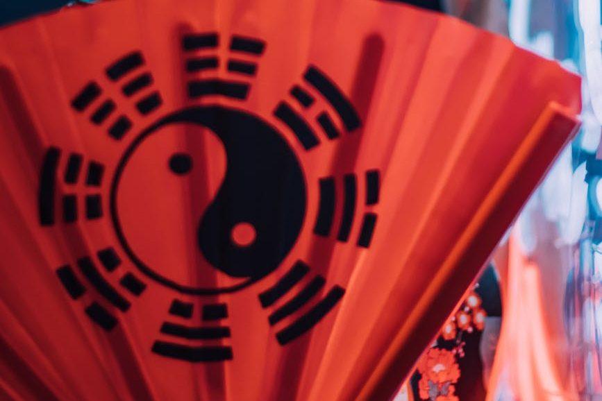 woman posing with yin i yang fan