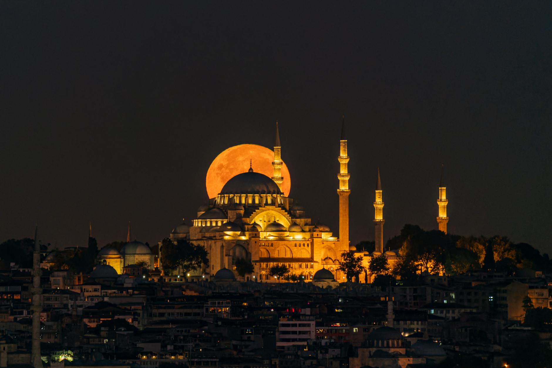 large moon behind illuminated suleymaniye mosque, illustrating: rare lunar phenomena, eclipse rituals, eclipse meaning, moon spiritual significance, and moon rituals