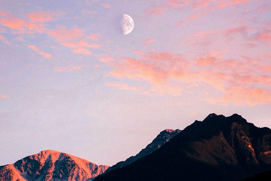 moon over mountains at dusk, showing: moon effects on humans, lunar rhythms, lunar phases and emotions, moon influence science, and moon biological rhythms