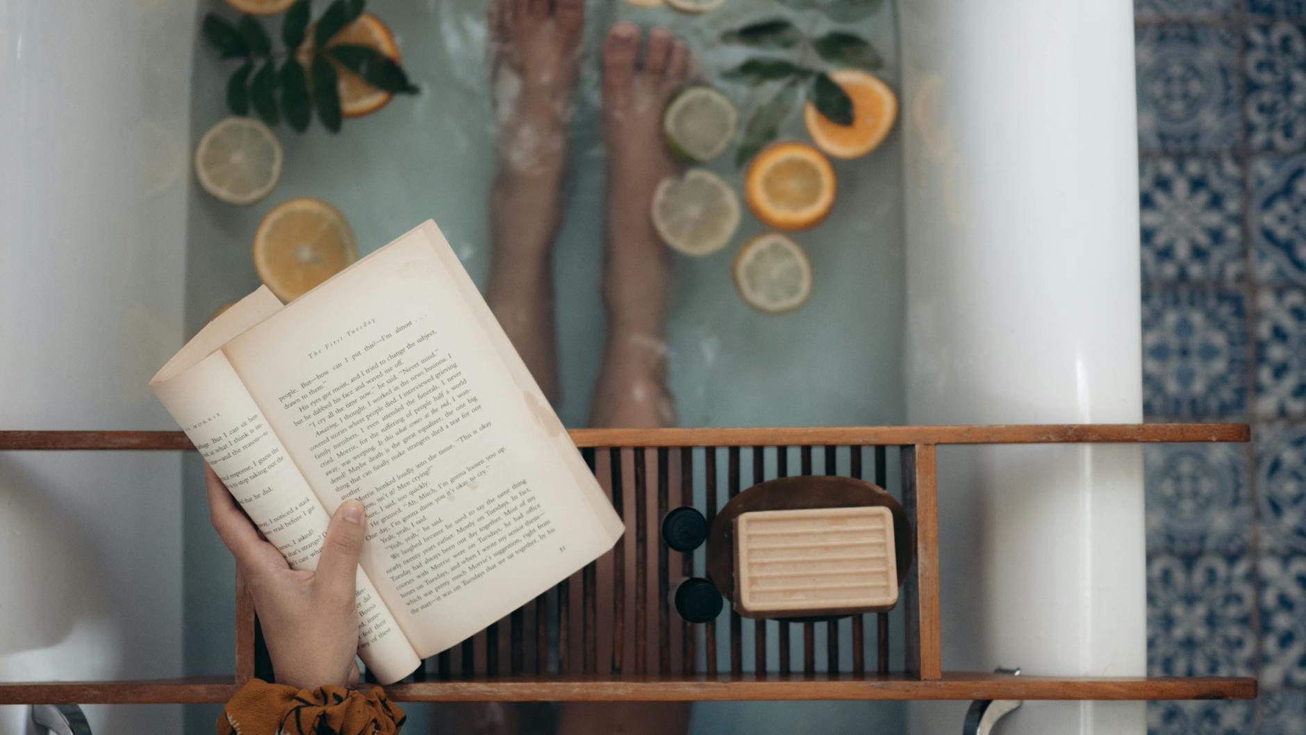 person holding book near brown wooden table, illustrating: moon rituals, lunar traditions, modern moon practices, lunar guidance, and intention setting rituals
