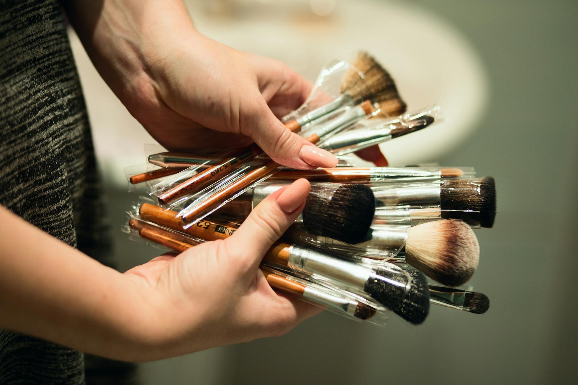 person holding makeup brushes