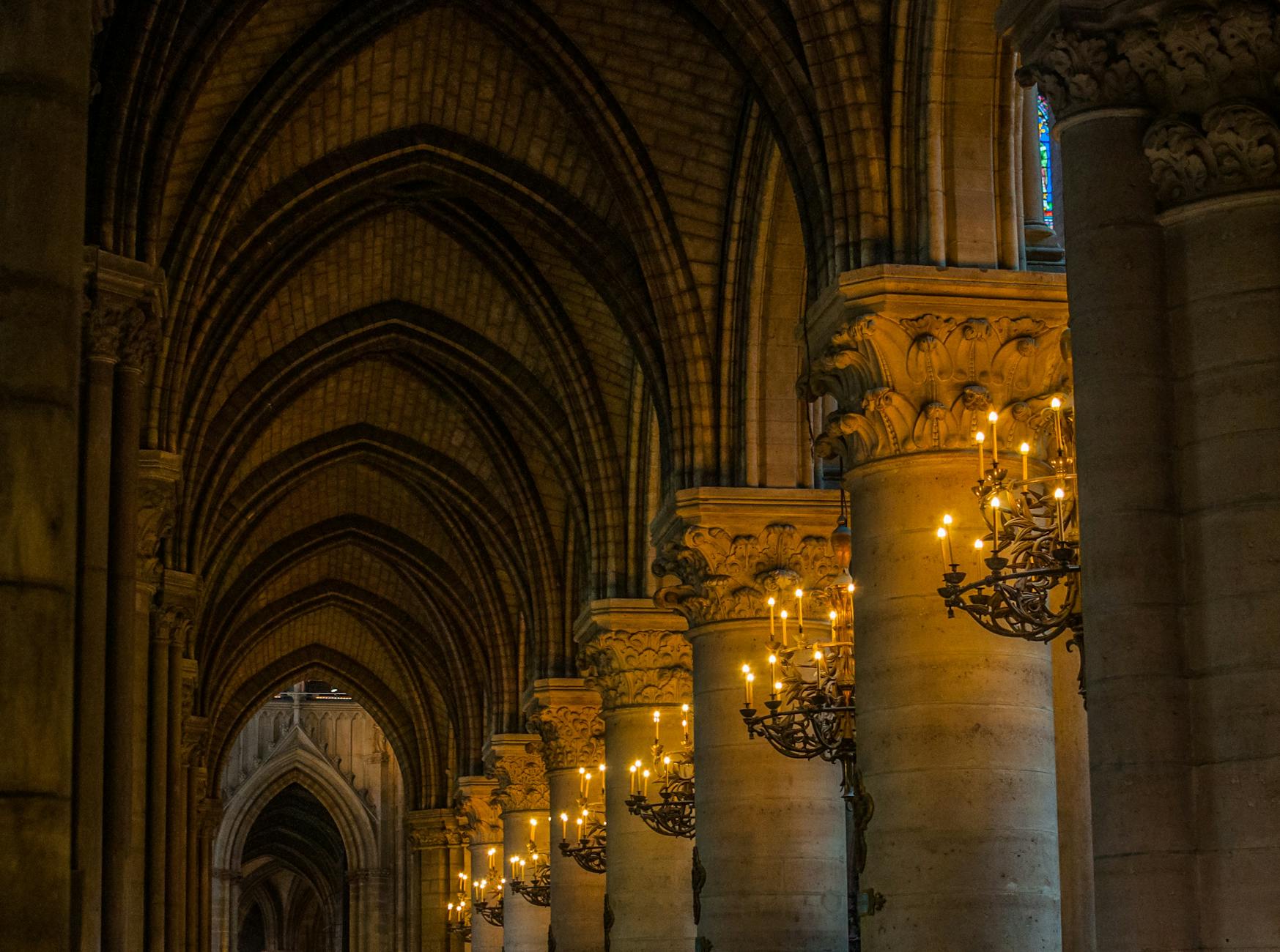 isle with lit chandeliers in between pillars