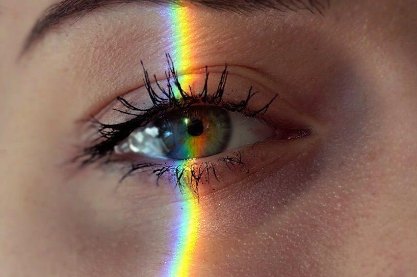anonymous woman with rainbow light on face