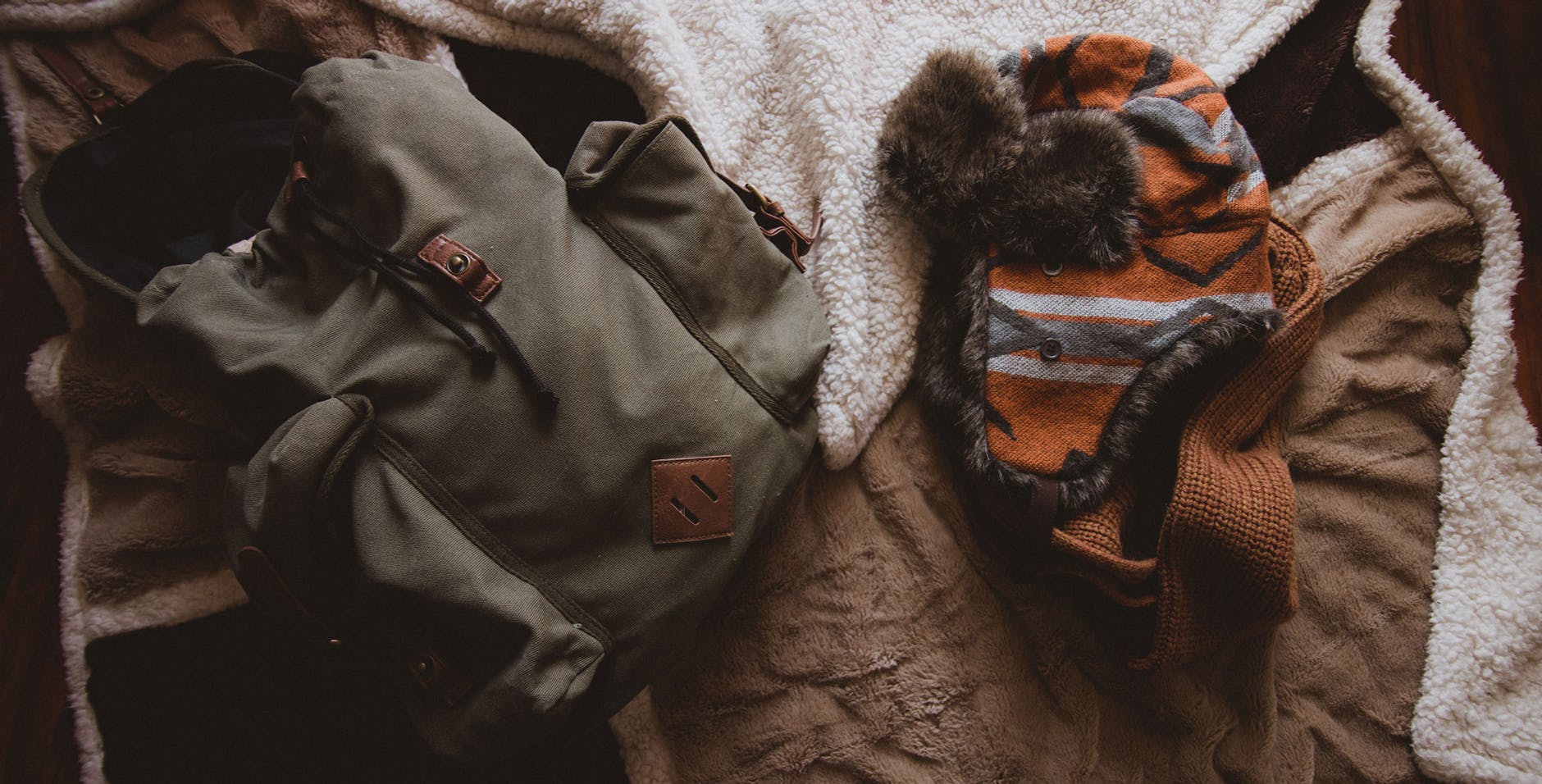 gray backpack beside orange knit hat