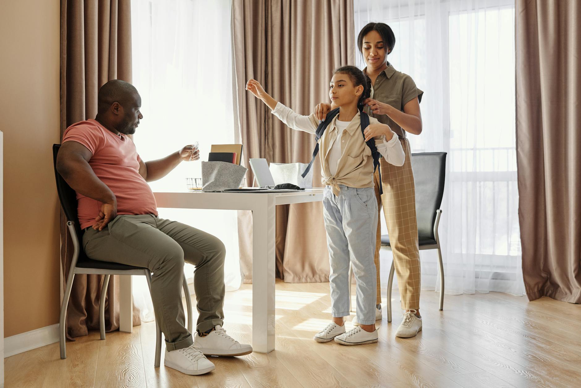 parents helping their daughter to get ready for school