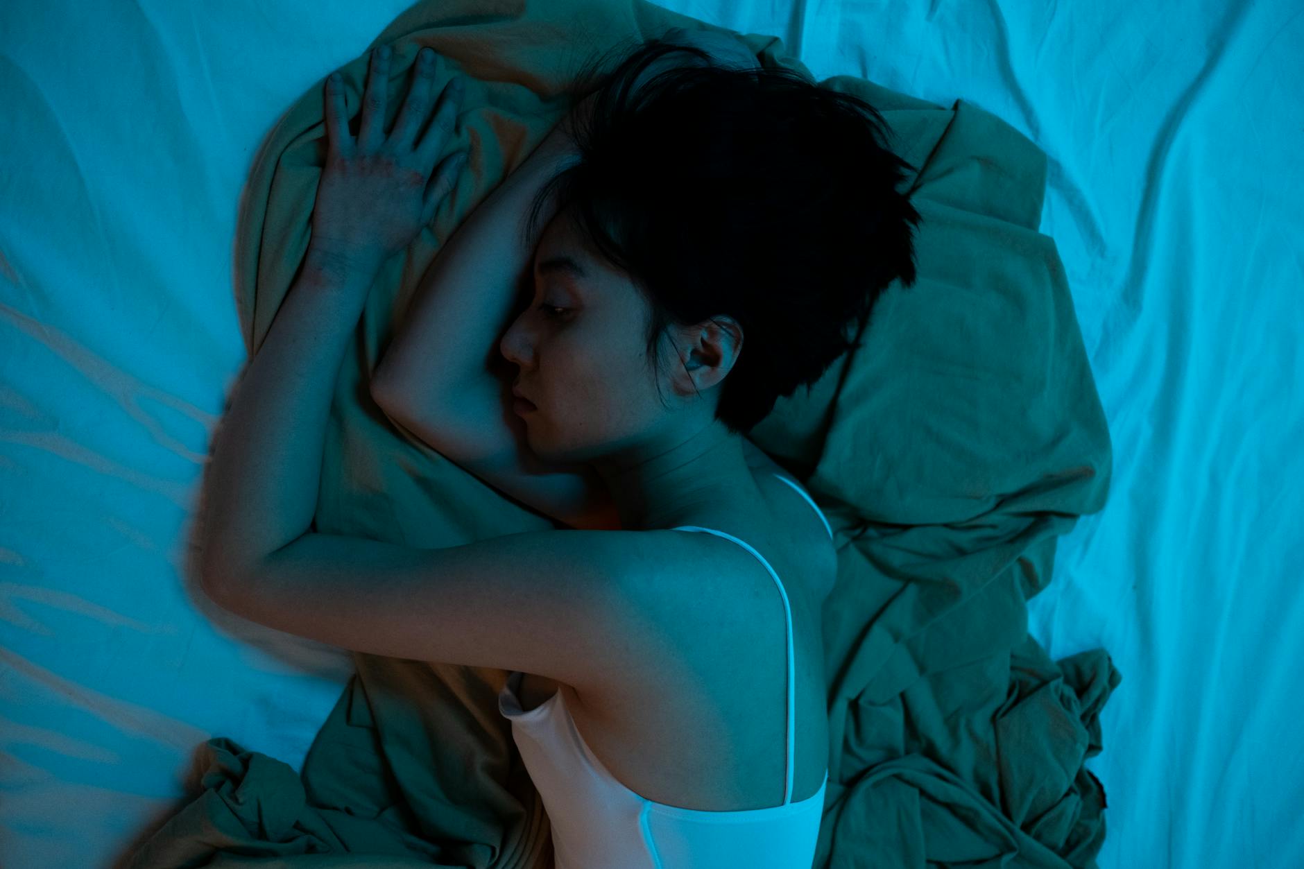 woman in white crop toplying on bed