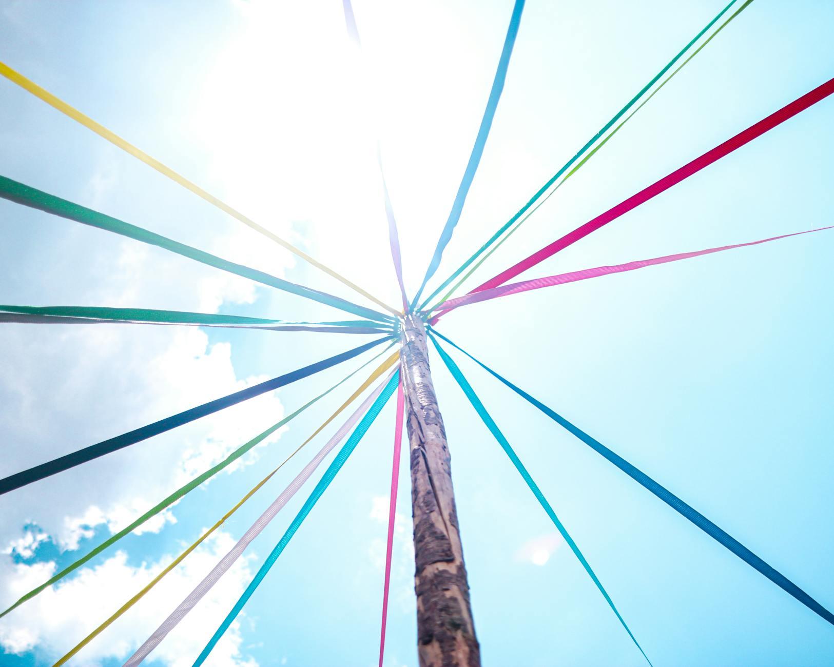 low angle shot of a may pole, evoking: natural cycles, Wheel of the Year, seasonal traditions, Sabbats, and holidays.