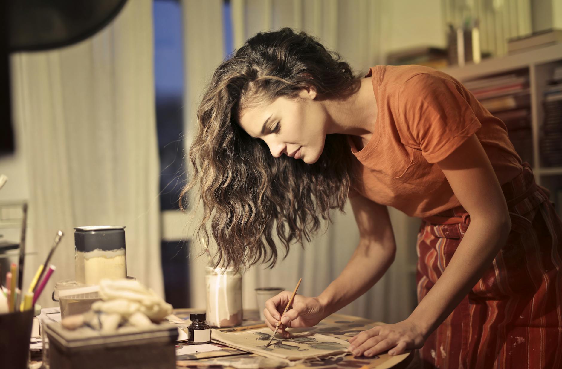 creative female artisan drawing in workshop, illustrating: holidays, rituals, holiday ritual, seasonal tradition, and traditions