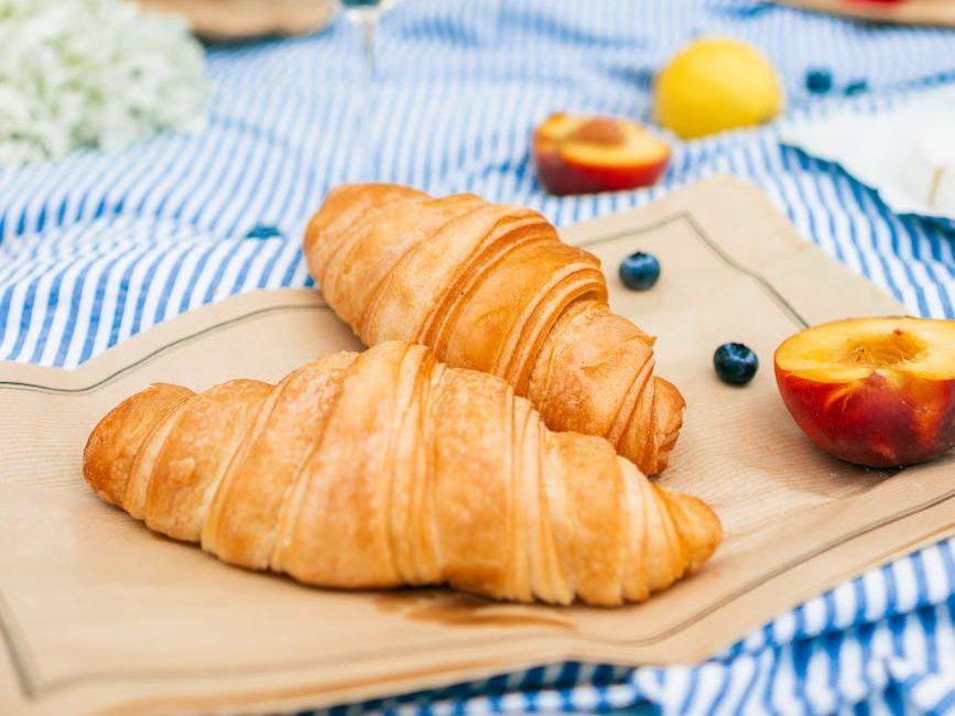 breads and fruits on blue picnic blanket, evoking: natural cycles, Wheel of the Year, seasonal traditions, Sabbats, and holidays.