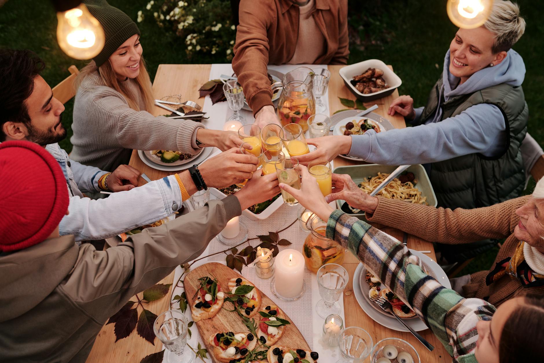 family doing a thanksgiving toasts, illustrating: holidays, rituals, holiday ritual, seasonal tradition, and traditions