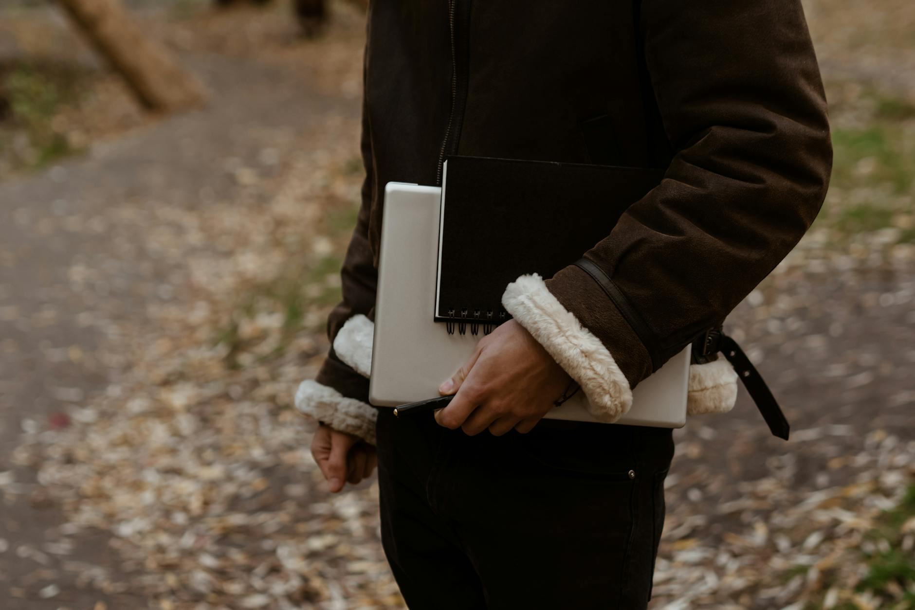 person in black jacket holding white book