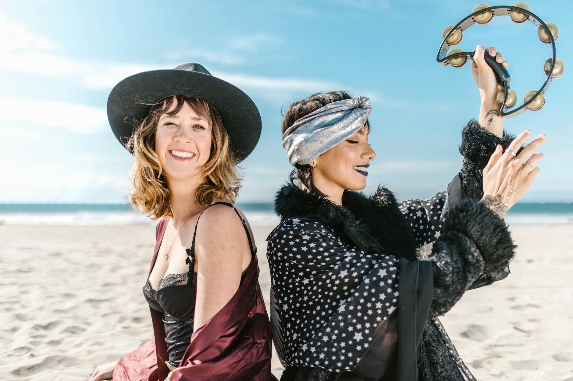 woman in black and white polka dot dress and black hat smiling, evoking: the Wheel of the Year, seasonal cycles, Sabbats, spiritual growth, and living seasonally