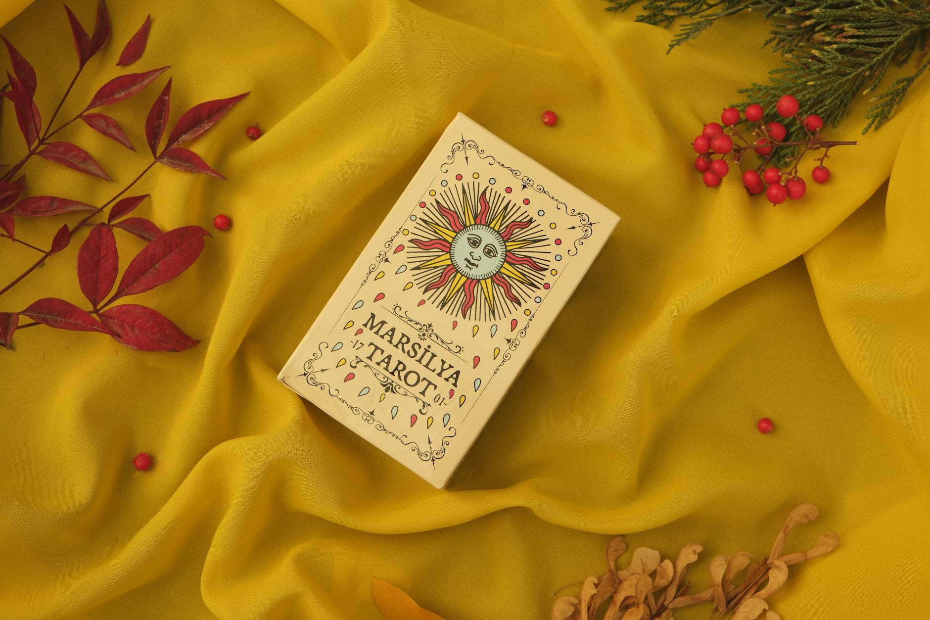 box of tarot cards on yellow back, evoking: a tarot spread for Samhain, ancestral guidance, transformation, and divination