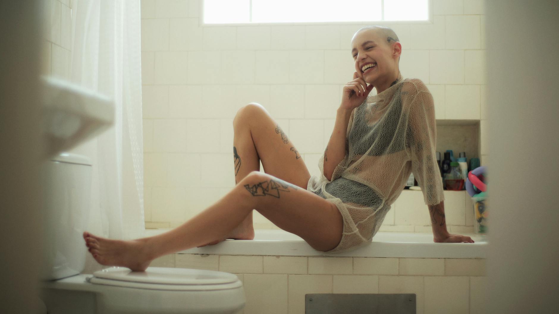 smiling woman sitting on bath tub, evoking: real manifestation, gratitude, abundance mindset, and intentional living