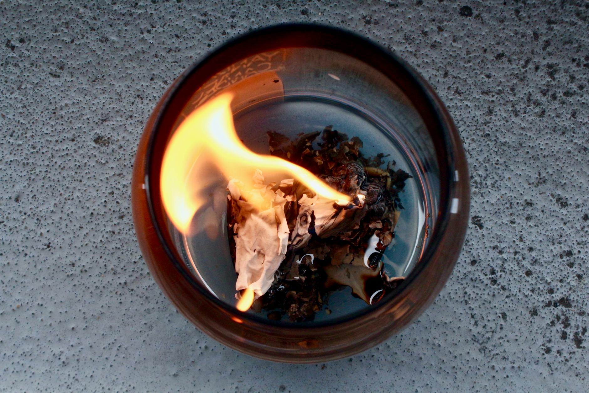 a glass container with burning paper