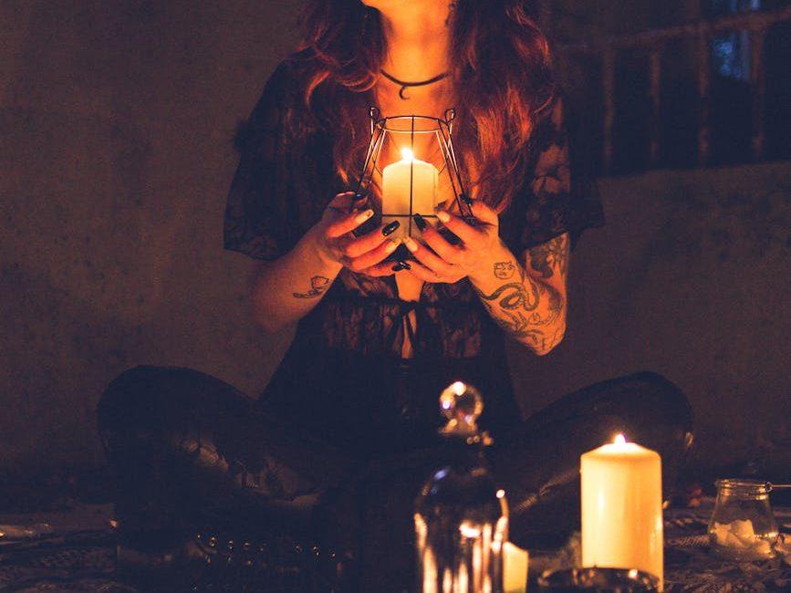spooky witch among candles during ritual, evoking: a tarot spread for Samhain, ancestral guidance, transformation, and divination