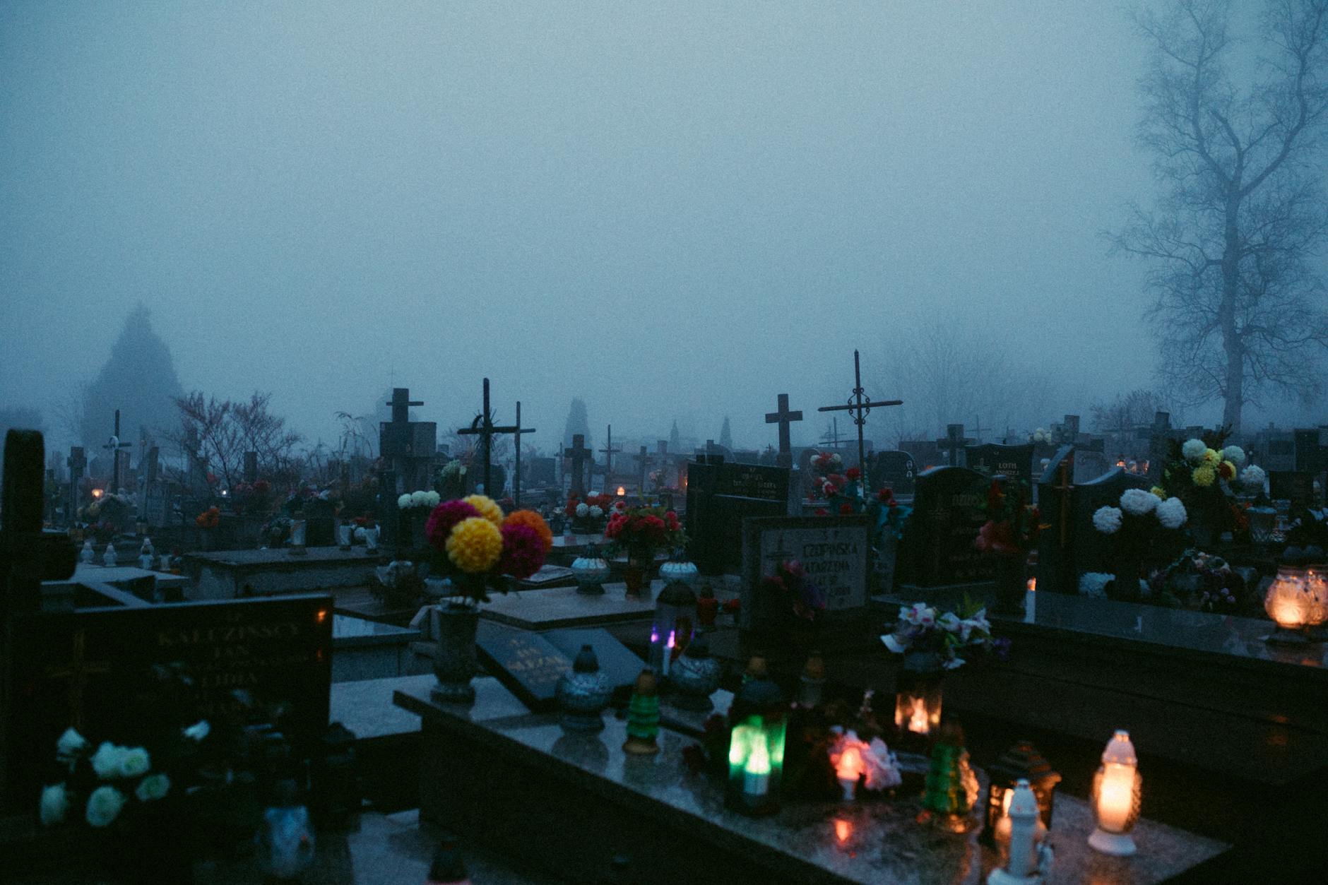 lighted candles and flowers on graves