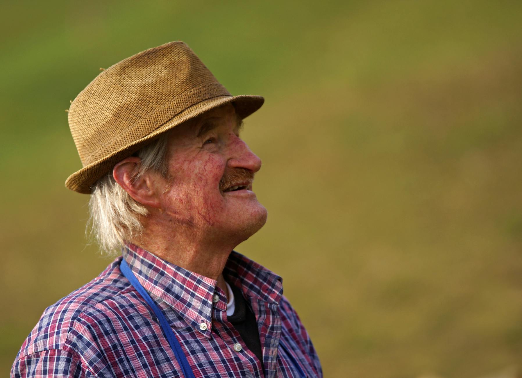 man wearing brown bucket hat, illustrating: alchemy, transforming hardship, gratitude, abundance, and resilience 